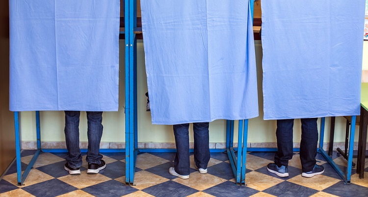 People's legs voting in voting booths